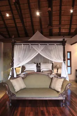 a large bed with a couch in a room at Shumbalala Game Lodge in Thornybush Game Reserve