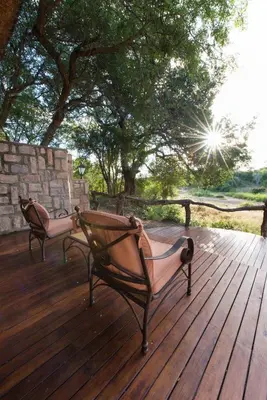 two benches sitting on top of a wooden deck at Shumbalala Game Lodge in Thornybush Game Reserve