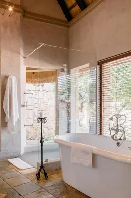 a large bathroom with a tub and a window at Shumbalala Game Lodge in Thornybush Game Reserve