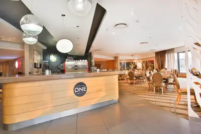 a restaurant with a counter and tables and chairs at RH Hotel & Apartments - Pretoria in Pretoria
