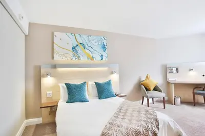 a hotel room with a bed and a desk at RH Hotel & Apartments - Pretoria in Pretoria
