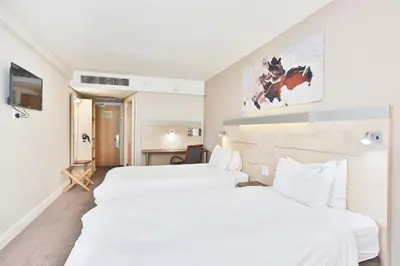 two beds in a hotel room with white sheets at RH Hotel & Apartments - Pretoria in Pretoria