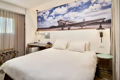 a hotel room with a large bed and a picture of a plane at Protea Hotel by Marriott O R Tambo Airport in Kempton Park