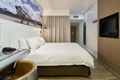 a hotel room with a bed and a flat screen tv at Protea Hotel by Marriott O R Tambo Airport in Kempton Park