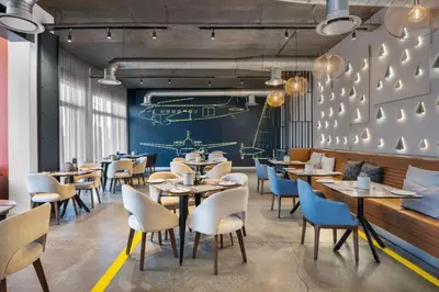 a restaurant with tables and chairs and a chalkboard at Protea Hotel by Marriott O R Tambo Airport in Kempton Park