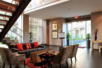 a living room with a couch and some chairs at Protea Hotel by Marriott O R Tambo Airport in Kempton Park