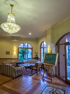 a living room with couches and a chandelier at The Elegant Lodge Menlo Park in Pretoria