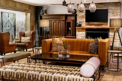 a living room with a couch and a table at Kruger Gate Hotel in Skukuza