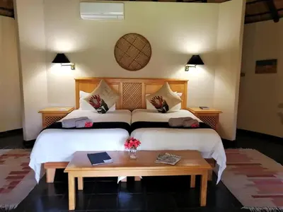 a bedroom with a large bed with a table at Idle & Wild Chalet in Hazyview