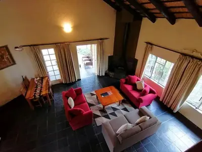 a living room with red chairs and a table at Idle & Wild Chalet in Hazyview