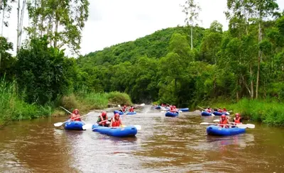 a group of people are kayaking down a river at Idle & Wild Chalet in Hazyview