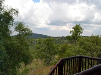 a balcony with a view of a field of trees at Elements Private Golf Reserve in Bela-Bela