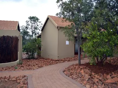 a house with a brick walkway next to a building at Elements Private Golf Reserve in Bela-Bela