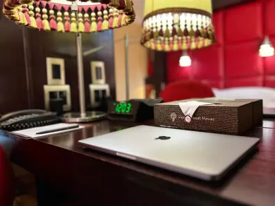 a laptop sitting on a desk with a box on it at Cycad Guest House in Polokwane