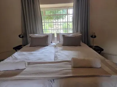 a large white bed in a room with a window at Three Bridges B&B in Hoedspruit