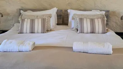 a large white bed with two pillows on it at Three Bridges B&B in Hoedspruit