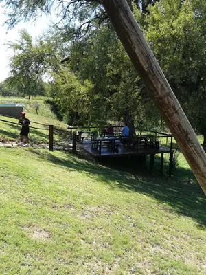 a group of people sitting at a picnic table in a park at Three Bridges B&B in Hoedspruit
