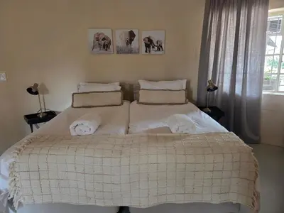 a bedroom with a large bed with white sheets and pillows at Three Bridges B&B in Hoedspruit