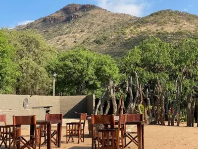 a group of chairs and tables in front of a mountain at Ithaba Falls Guest Farm Farm L59, Buffelsvley, Burgersfort, 1150 in Boerboomskraal