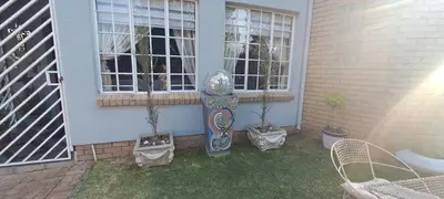 a garden in front of a house with two windows at De Zevende Hemel Guesthouse in Secunda