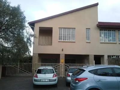 two cars parked in front of a house at De Zevende Hemel Guesthouse in Secunda