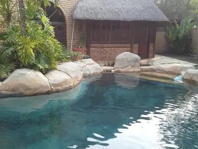 a pool of water with a building in the background at De Zevende Hemel Guesthouse in Secunda
