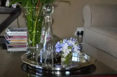 a glass vase with flowers on a coffee table at Plumbago Guest House in Hazyview