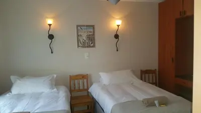 a bedroom with two beds and two lights on the wall at Lani's Guest House - No Loadshedding in Musina