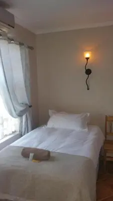 a white bed with a stuffed animal on top of it at Lani's Guest House - No Loadshedding in Musina