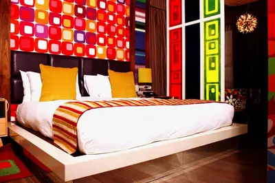 a bedroom with a large bed with colorful walls at Peermont Metcourt - Thaba Moshate in Burgersfort