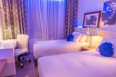 a bedroom with two beds and a desk with a lamp at Peermont Metcourt - Thaba Moshate in Burgersfort