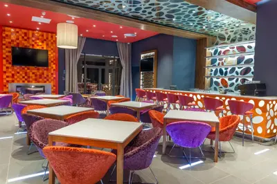 a restaurant with tables and chairs and a bar at Peermont Metcourt - Thaba Moshate in Burgersfort