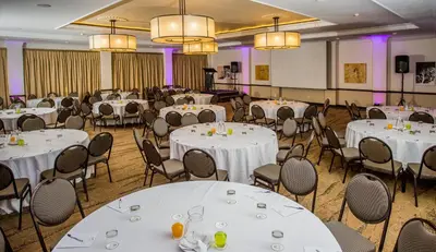 a banquet hall with white tables and chairs at The Centurion Hotel in Centurion