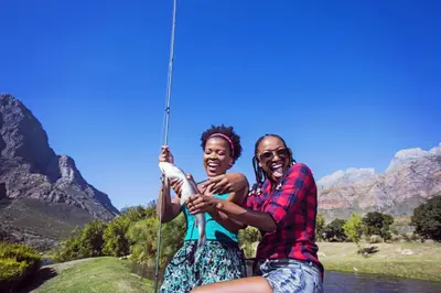 a man and a woman holding a fishing pole at Woodlands Guest House in Hazyview