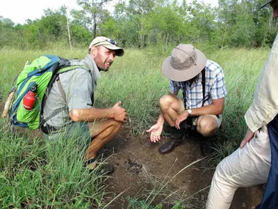 a group of people kneeling down in the mud at Rhino Walking Safaris in Skukuza