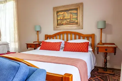 a bedroom with a large bed with red pillows at Waters on Willows in Pretoria