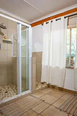 a shower with a glass door in a bathroom at Waters on Willows in Pretoria