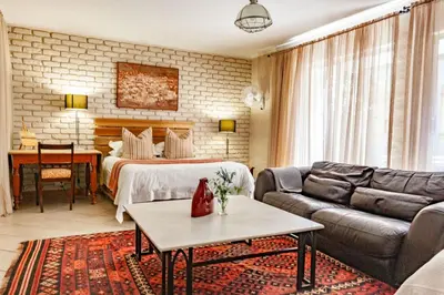 a living room with a bed and a couch at Waters on Willows in Pretoria