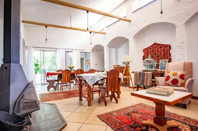 a living room with a table and a fireplace at Waters on Willows in Pretoria