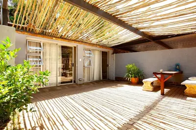 a patio with a pergola with a table and a bench at Waters on Willows in Pretoria