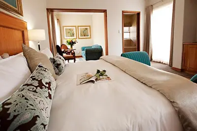 a large white bed with a book on it at Mavuta Manor in Polokwane