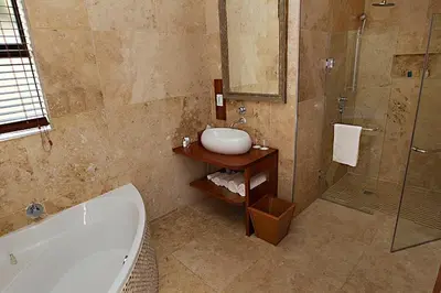 a bathroom with a tub and a sink and a shower at Mavuta Manor in Polokwane