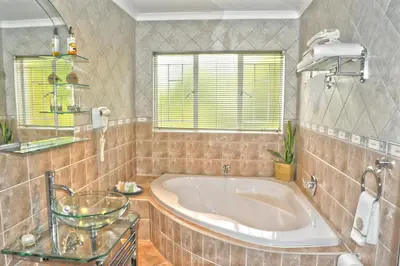 a large bathroom with a tub and a window at Ipe Tombe Guest Lodge - Midrand in Midrand
