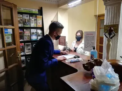 a man and a woman wearing face masks at a desk at Ipe Tombe Guest Lodge - Midrand in Midrand