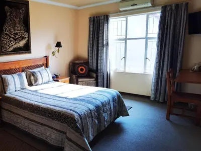 a bedroom with a bed and a large window at Ipe Tombe Guest Lodge - Midrand in Midrand