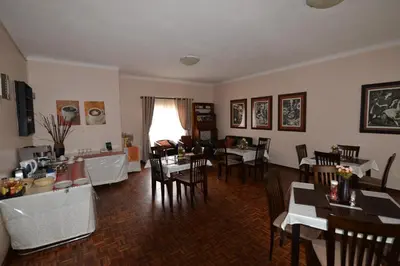 a dining room with tables and chairs in a room at Attaché Guest Lodge & Health Spa in Midrand