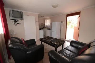 a living room with a couch and a table at Attaché Guest Lodge & Health Spa in Midrand