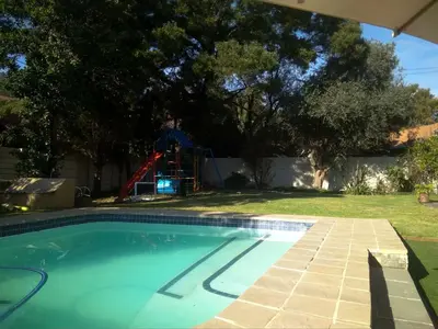 a man is standing next to a swimming pool at Limonite GuestHouse in Pretoria