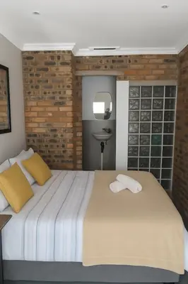a bedroom with a bed with two towels on it at Limonite GuestHouse in Pretoria