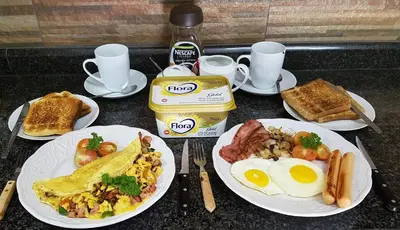 a table topped with plates of breakfast food with eggs and toast at Big Boma Guest House in Lydenburg